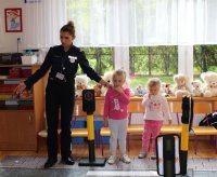 policjant i przedszkolaki  w trakcie pogadanki w ramach  akcji Ogólnopolskiego Policyjnego Dnia Odblasków
