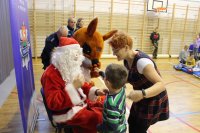 policjanci wraz ze Św. Mikołajem i dziećmi w trakcie spotkania profilaktycznego na sali gimnastycznej
