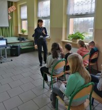 policjantka wraz z uczniami w trakcie pogadanki na temat bezpiecznego korzystania z internetu