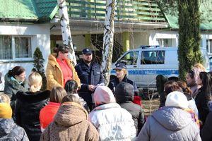policjantka stoi na dworze pośród uchodźców z Ukrainy i prowadzi pogadankę