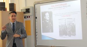 w sali szkoły Prezes Stowarzyszenia Rodzina Policyjna 1939 w Łodzi prowadzi prelekcję historyczną z wykorzystaniem prezentacji mulimedianej