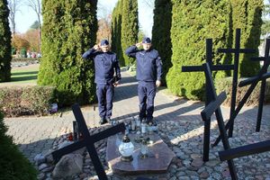 Policjanci oddają honory przy Mogile Katyńskiej&amp;quot; na wieluńskim cmentarzu.