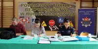 kolorowe zdjęcie przedstawiające komisję konkursową  sprawdzających  test wiedzy   podczas  powiatowych eliminacji Turnieju Bezpieczeństwa w Ruchu Drogowym