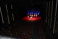kolorowe zdjęcie ukazujące salę Kinową gdzie odbywa się projekt profilaktyczny. Na scenie widoczny jest artysta Gabriel Fleszar, na sali kinowej publiczność.