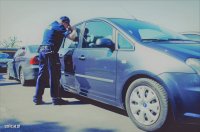 zdjęcie przedstawiające policjanta przed samochodem
