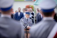 zdjęcie ukazujące przemawiającego Komendanta Powiatowego Policji w Bełchatowie do  zgromadzonych na placu Narutowicza  podczas międzypowiatowych obchodów Święta Policji w Bełchatowie