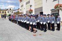 zdjęcie ukazujące  poczty sztandarowe oraz policjantów  mianowania na wyższe stopnie  zgromadzonych na placu Narutowicza  podczas międzypowiatowych obchodów Święta Policji w Bełchatowie