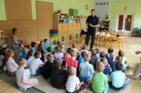 kolorowe zdjęcie przedstawiające policjanta oraz dzieci przedszkolne w trakcie spotkania profilaktycznego.