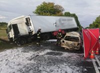 kolorowe zdjęcie przedstawiające  miejsce wypadku drogowego, w którym zderzyły się dwa samochody osobowy z ciężarówką oraz pracujących strażaków
