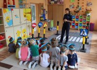 policjantka z przedszkolakami w trakcie pogadanki edukacyjno- profilaktycznej na temat bezpieczeństwa