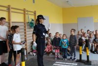 policjantka z przedszkolakami w trakcie pogadanki edukacyjno- profilaktycznej na temat bezpieczeństwa