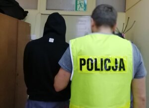 policjant prowadzi zatrzymanego