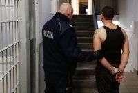 policjant prowadzi zatrzymanego