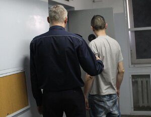 policjant prowadzi zatrzymanego