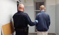 policjant prowadzi zatrzymanego