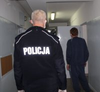 policjant prowadzi zatrzymanego