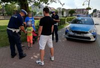 zdjęcie przedstawiające policjantów przekazujących maseczki ochronne mieszkańcom powiatu wieluńskiego