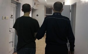 policjant prowadzi zatrzymanego do celi w policyjnym areszcie