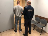 policjant prowadzi zatrzymanego do policyjnego aresztu