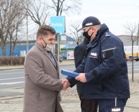 na parkingu przed budynkiem wieluńskiej komendy Komendant Powiatowy Policji  wraz z zastępcą  wręcza pamiątkową tabliczkę burmistrzowi.