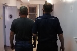 korytarz komendy, policjant prowadzi zatrzymanego mężczyznę