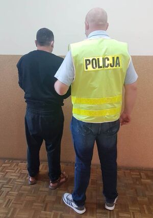 korytarz komendy, policjant prowadzi zatrzymanego mężczyznę