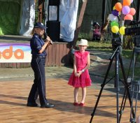 Policjantka w trakcie wydarzenia plenerowego &quot;Emdekolada&quot; na placu Powiatowego Młodzieżowego Domu Kultury i Sportu w Wieluniu.  Policjantka prowadzi pogadankę profilaktyczną dla uczestników.