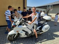 chłopiec siedzący na policyjnym motocyklu