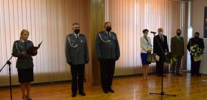 sala konferencyjna w wieluńskiej komendzie. Na pierwszym planie Komendant  Powiatowy Policji  w Wieluniu oraz jego zastępca. Obok stoją zaproszeni na uroczystość goście.