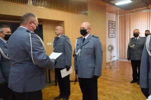 sala konferencyjna w wieluńskiej komendzie. Pododdział umundurowanych funkcjonariuszy mianowanych na wyższe stopnie policyjne. Komendant Powiatowy Policji w Wieluniu oraz jego zastępca wręczają akty mianowania.