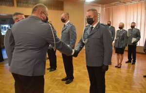 sala konferencyjna w wieluńskiej komendzie. Pododdział umundurowanych funkcjonariuszy mianowanych na wyższe stopnie policyjne. Komendant Powiatowy Policji w Wieluniu oraz jego zastępca wręczają akty mianowania.