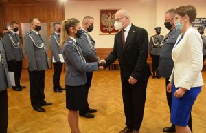 sala konferencyjna w wieluńskiej komendzie. Pododdział umundurowanych funkcjonariuszy mianowanych na wyższe stopnie policyjne. Starosta w obecności  Komendanta Powiatowego Policji w Wieluniu oraz Zastępcy Burmistrza wręcza listy gratulacyjne wyróżnionym policjantom.