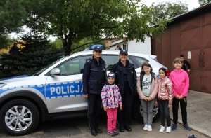 policjantki z dziećmi pozują na tle radiowozu