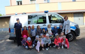 policjantka z dziećmi  na tle radiowozu