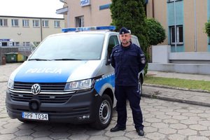 zdjęcie przedstawiające funkcjonariusza Wydziału Prewencji przy policyjnym radiowozie