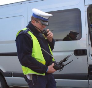 policjant- operator drona rozmawia przez radiostację