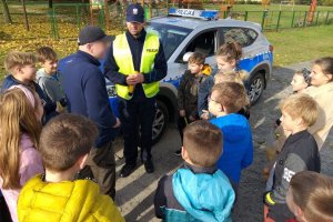 policjant z dziećmi przeprowadza rozmowę z kierowcą