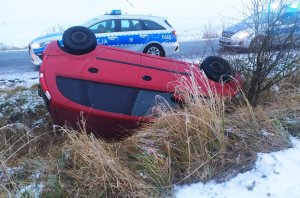 auto leżące w rowie obok na drodze stoją dwa radiowozy