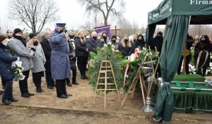 Komendant KPP w Wieluniu oddaje honor przed grobem zmarłego