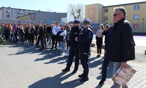 policjanci, zaproszeni goście oraz młodzież stoją przed halą sportową na terenie Zespołu Szkół nr 1  w Wieluniu