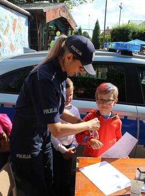 zdjęcie przedstawiające policjantkę oraz uczestników &quot;EMDEKOLADY&quot;