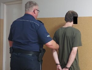 policjant prowadzi zatrzymanego