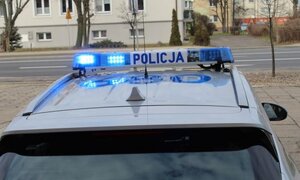 Sygnały świetlne na dachu radiowozu, napis Policja.