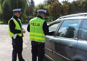 Policjanci stoją przy kontrolowanym pojeździe.