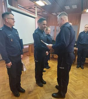 Komendant Powiatowy Policji w Wieluniu wręcza akt mianowania policjantowi.