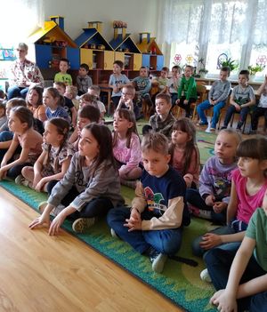 Dzieci siedzą w sali podczas pogadanki.