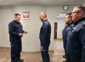Komendant Powiatowy Policji w Wieluniu wręcza rozkaz personalny o powołaniu na stanowisko Komendanta Komisariatu Policji w Osjakowie, z boku stoją policjanci.