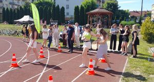 Piknik na boisku gdzie zgromadzeni są  uczestnicy, którzy korzystają z alko i narkogogli pokonując tor przeszkód.