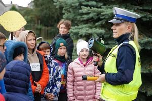 Policjantka prezentuje dzieciom urządzenia do badania stanu trzeźwości i pomiaru prędkości.