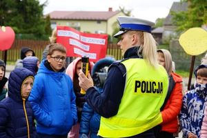 Policjantka prezentuje uczniom urządzenie do badania stanu trzeźwości.